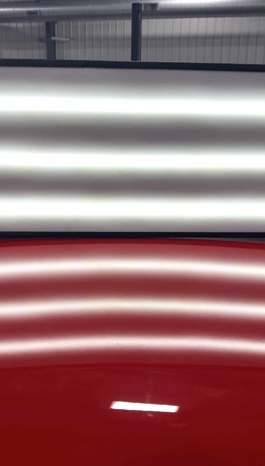 Same red panel after paintless dent repair, reflection lines clean and dents removed