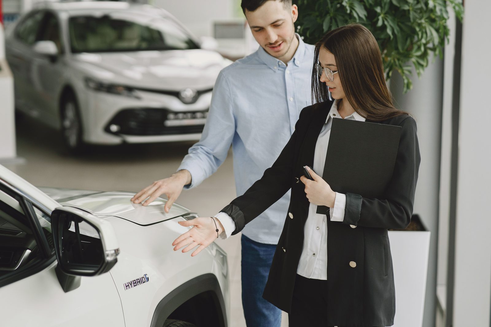 Service advisor reviewing a completed repair with a customer beside their vehicle