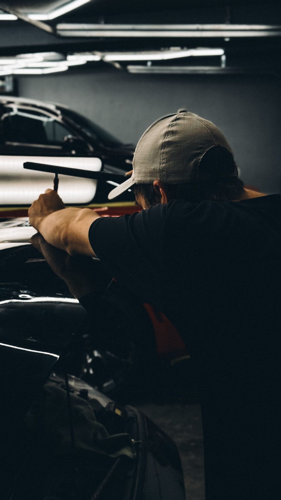 Technician performing paintless dent repair on a vehicle